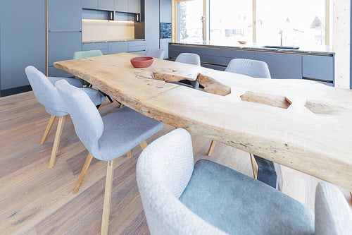 Großer rustikaler Holztisch mit modernen Stühlen