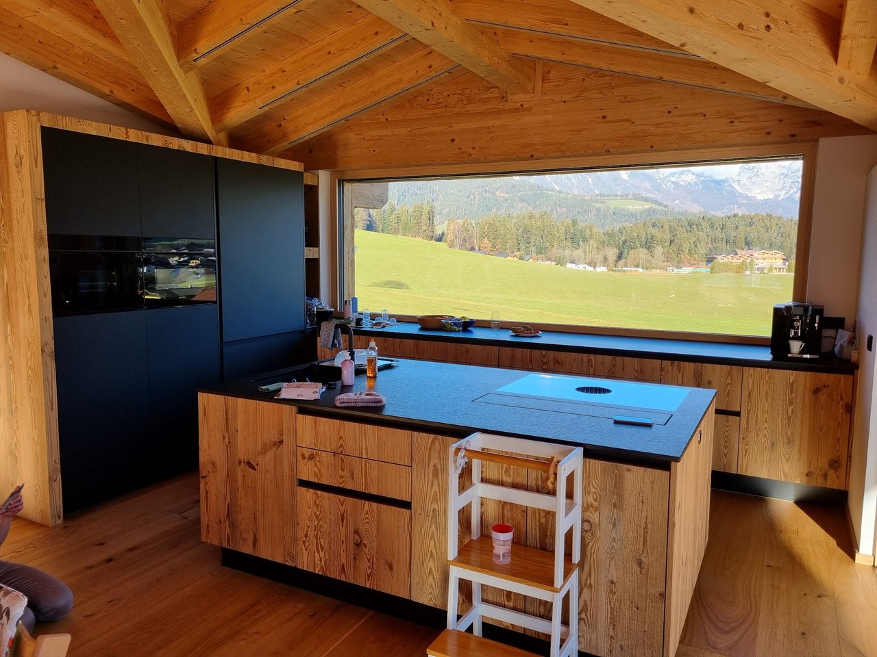 Moderne Holzküche mit schwarzer Arbeitsplatte
